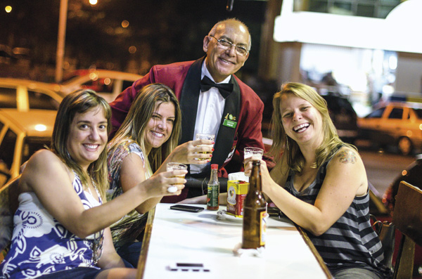 O garçom Cícero Rodrigues, patrimônio boêmio de Brasília, com três amigas frequentadoras do Beirute: algo mais que cerveja gelada
 (Raimundo Sampaio/Encontro/DA Press)
