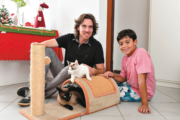 André Luis Gomes Moreira, com o filho, Caio, e os gatos Catarina e Tony: 'Adotar é acolher, cuidar e amar por uma vida toda' (Bruno Pimentel/Encontro/DA Press)